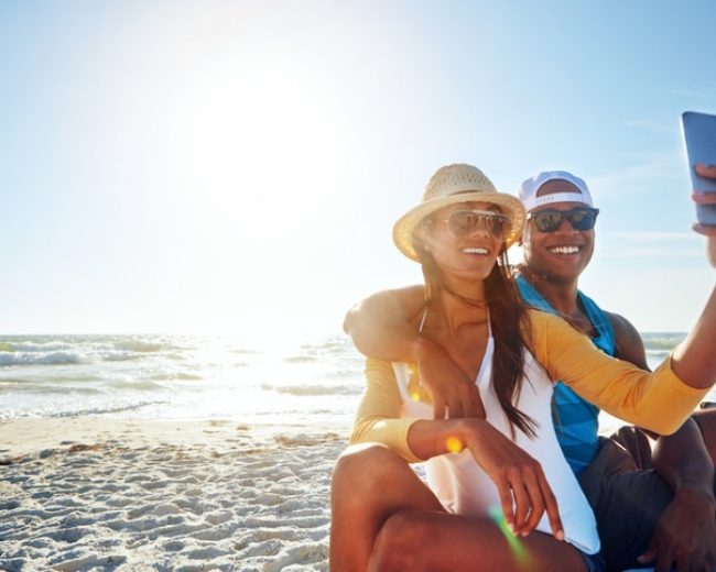 Shot of a happy young couple taking a selfie on the beach