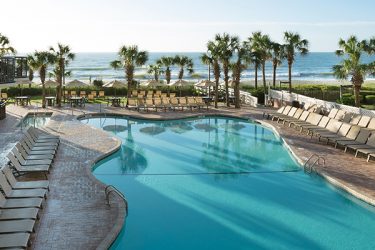 outdoor pool deck with ocean in background