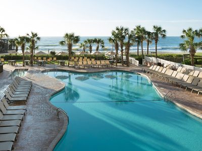 outdoor pool deck with ocean in background